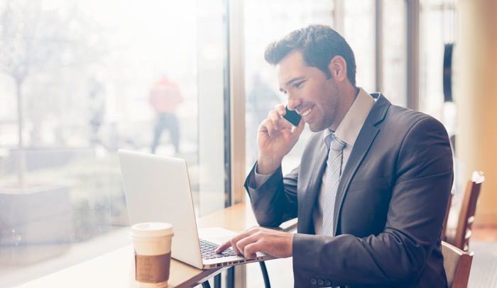 business man sitting at a cafe discussing his health options on his cell phone