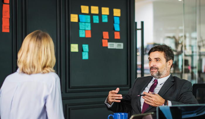 business man explain the basics of group health insurance in an office